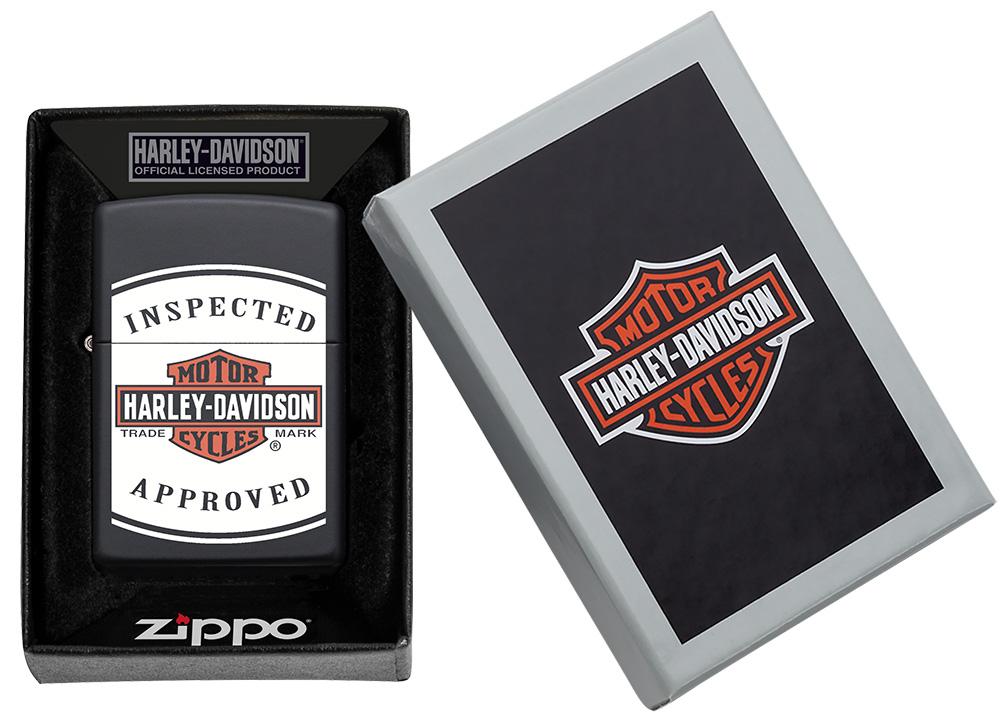 Vue de face briquet Zippo noir mat avec logo Harley Davidson et lettrage Inspected Approved dans une boîte cadeau Zippo ouverte