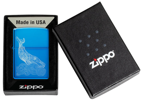 Briquet Zippo Whale Design bleu clair brillant dans son emballage ouvert avec une baleine gravée avec des vagues rondes