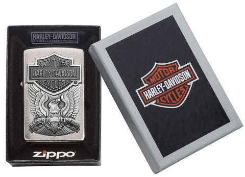 Vue de face chrome brossé avec aigle et emblème Harley Davidson, ouvert avec flamme dans un emballage cadeau ouvert