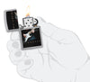 Briquet Zippo vue de face chromé ouvert et allumé avec une image colorée d'Eric Clapton jouant de la guitare dans la main stylistique