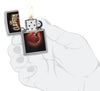Briquet Zippo vue de face chromé ouvert et allumé avec une image colorée d'une guitare rouge d'Eric Clapton dans la main stylistique