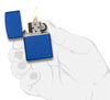 Vue de face briquet Zippo bleu royal mat modèle de base, ouvert avec flamme dans une main stylisée