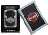 Vue de face briquet Zippo Satin Chrome avec logo Harley Davidson et fond noir, dans un emballage cadeau ouvert