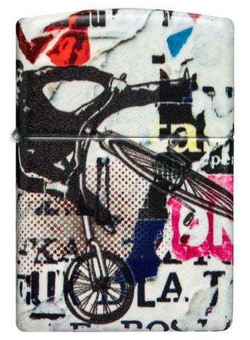 Briquet Zippo 540° vue de face et fait de métal, avec une illustration en couleur inspiré de l'art de la rue, qui montre un cycliste téméraire au-dessus d'un collage d'autocollants et de tracts.