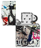 Briquet Zippo 540° vue de face ouvert et fait de métal, avec une illustration en couleur inspiré de l'art de la rue, qui montre un cycliste téméraire au-dessus d'un collage d'autocollants et de tracts.