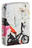 Briquet Zippo ¾ angle 540° vue de côté et fait de métal, avec une illustration en couleur inspiré de l'art de la rue, qui montre un cycliste téméraire au-dessus d'un collage d'autocollants et de tracts.