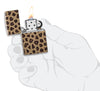 Briquet Zippo 540° vue de face en main stylisée  ouvert et allumé et fait de métal, avec une illustration en couleur qui montre l'imprimé léopard classique
