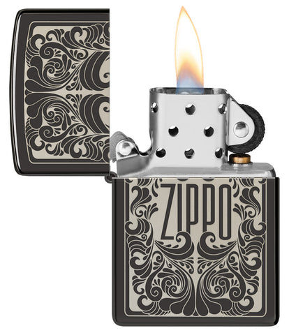 Briquet Zippo vue de face ouvert et allumé et fait de métal, avec une illustration en couleur qui montre le nom de Zippo a été gravé au laser dans un motif tourbillonnant et fluide.