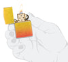 Briquet Zippo 540° vue de face ouvert et allumé en main stylisée et fait de métal, avec une illustration en couleur qui montre les tons jaunes dorés se fondent dans les tons orange ardents pour créer un effet ombré luxueux.