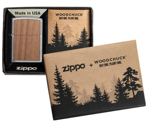 Vue de face briquet Zippo chrome brossé avec emblème Woodchuck, ouvert avec flamme, dans une boîte cadeau ouverte