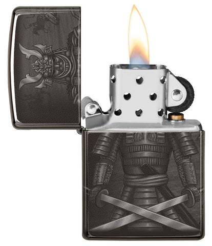 Vue de face briquet Zippo noir brillant avec samouraï et épées croisées, ouvert avec flamme