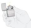Briquet Zippo chromé avec logo Zippo, ouvert avec flamme dans une main stylisée