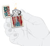Briquet Zippo vue de face Mercury Glass ouvert et allumé avec illustration en couleur de la Statue de la Liberté et drapeau américain en arrière-plan dans une main stylisée