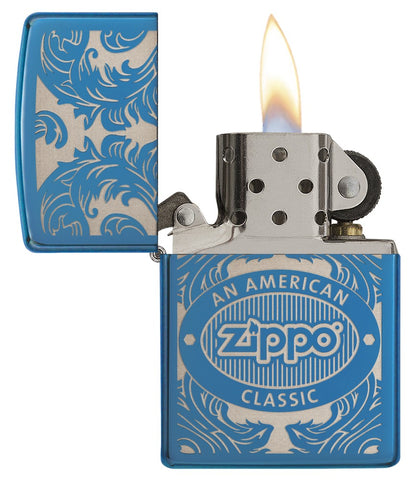 Briquet Zippo bleu vue de face ouvert avec une flamme entouré d’un motif en filigrane gravé au laser qui montre le logo de Zippo et de "an american classic".