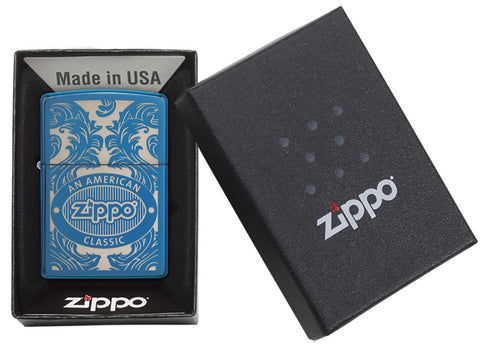 Briquet Zippo bleu vue de face dans une boite cadeau noire ouverte entouré d’un motif en filigrane gravé au laser qui montre le logo de Zippo et de 