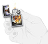 Briquet Zippo pochette Iron Maiden The Wicker Man, ouvert avec flamme dans une main stylisée