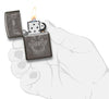 Briquet Zippo gris brillant tête de loup, ouvert avec flamme dans la main stylisée