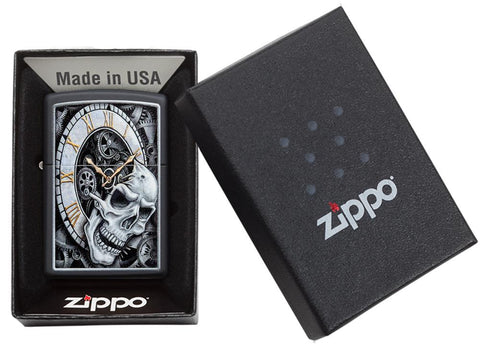 Briquet Zippo noir horloge d'où émerge une tête de mort avec des engrenages en arrière-plan, dans un coffret cadeau ouvert