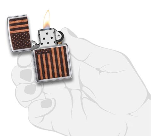 Zippo Woodchuck avec drapeau américain, ouvert avec flamme dans une main stylisée