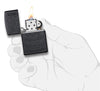  Briquet Zippo noir avec motif mandala, ouvert avec flamme dans une main stylisée