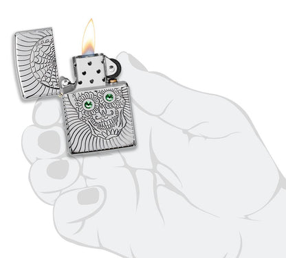 Briquet Zippo avec gravure profonde tête de mort et yeux en éléMen,ts Swarovski, ouvert avec flamme dans une main stylisée
