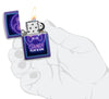 Briquet Zippo violet avec manette et lettrage Play & Win, ouvert avec flamme dans une main stylisée