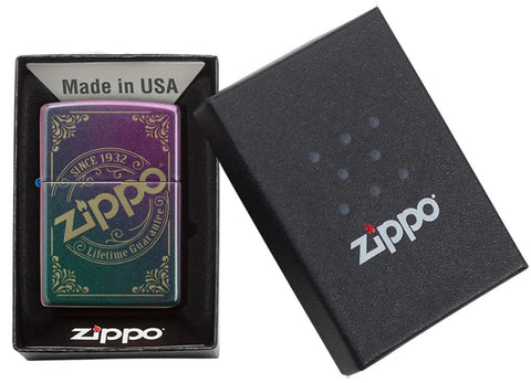 Vue de face briquet Zippo iridescent mat avec estampe du logo Zippo gravé au laser dans une boîte cadeau ouverte 