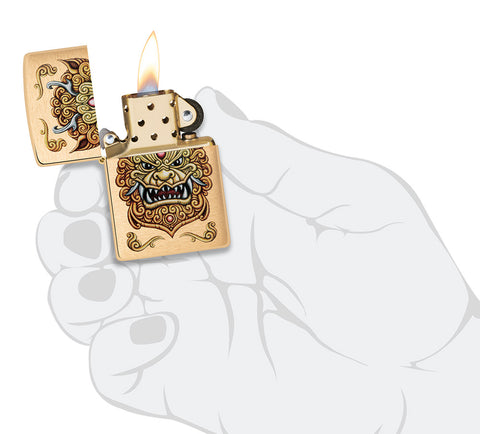 Briquet Zippo coupe-vent Foo Dog Design dans une main pour représenter la taille du briquet, montrant un lion doré impérial dans le style de l'art chinois.