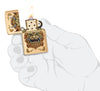 Briquet Zippo coupe-vent Foo Dog Design dans une main pour représenter la taille du briquet, montrant un lion doré impérial dans le style de l'art chinois.