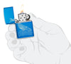Briquet Zippo vue de face ouvert et allumé Baleine Design bleu clair brillant avec une baleine gravée avec des vagues rondes en main stylisée